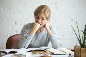 Woman sitting on her desk feeling anxious with workload